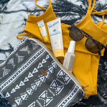 Load image into Gallery viewer, Yellow bikini with pouch, sunscreen, and sunglasses on a textured surface
